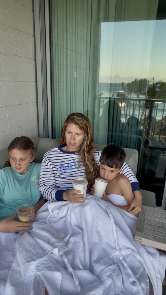 a mother with her two children on a lounger on the porch of their room at The Ritz-Carlton Oahu, Turtle Bay